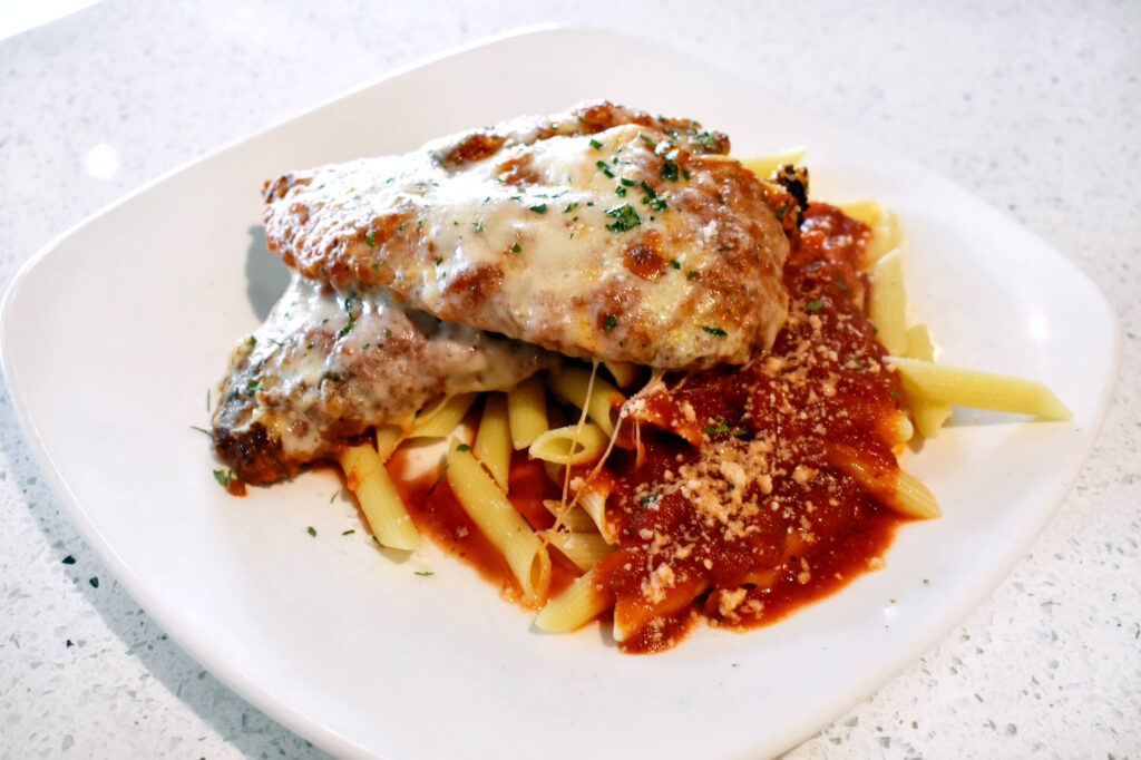 chicken parmigiana with penne pasta at Christos Restaurant and Bar